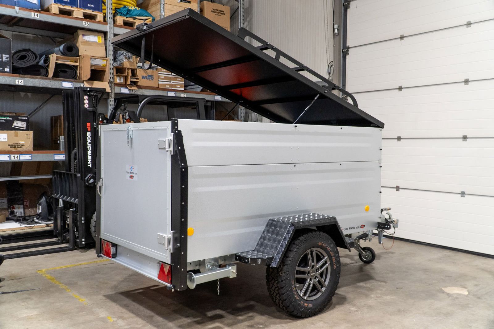 Silberner TPV-Kofferanhänger EB3 Offroad mit geöffnetem Deckel in der Halle