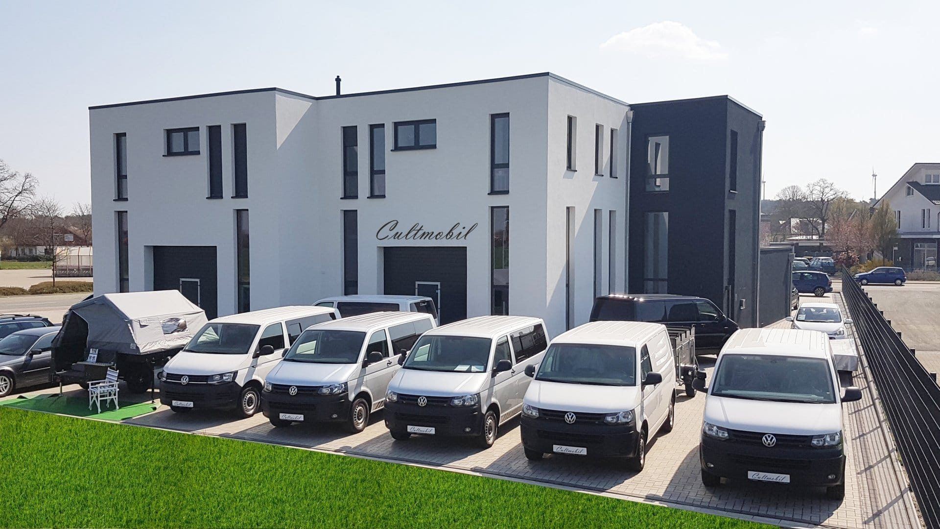 Cultmobil-Gebäude mit Parkplatz und Campern