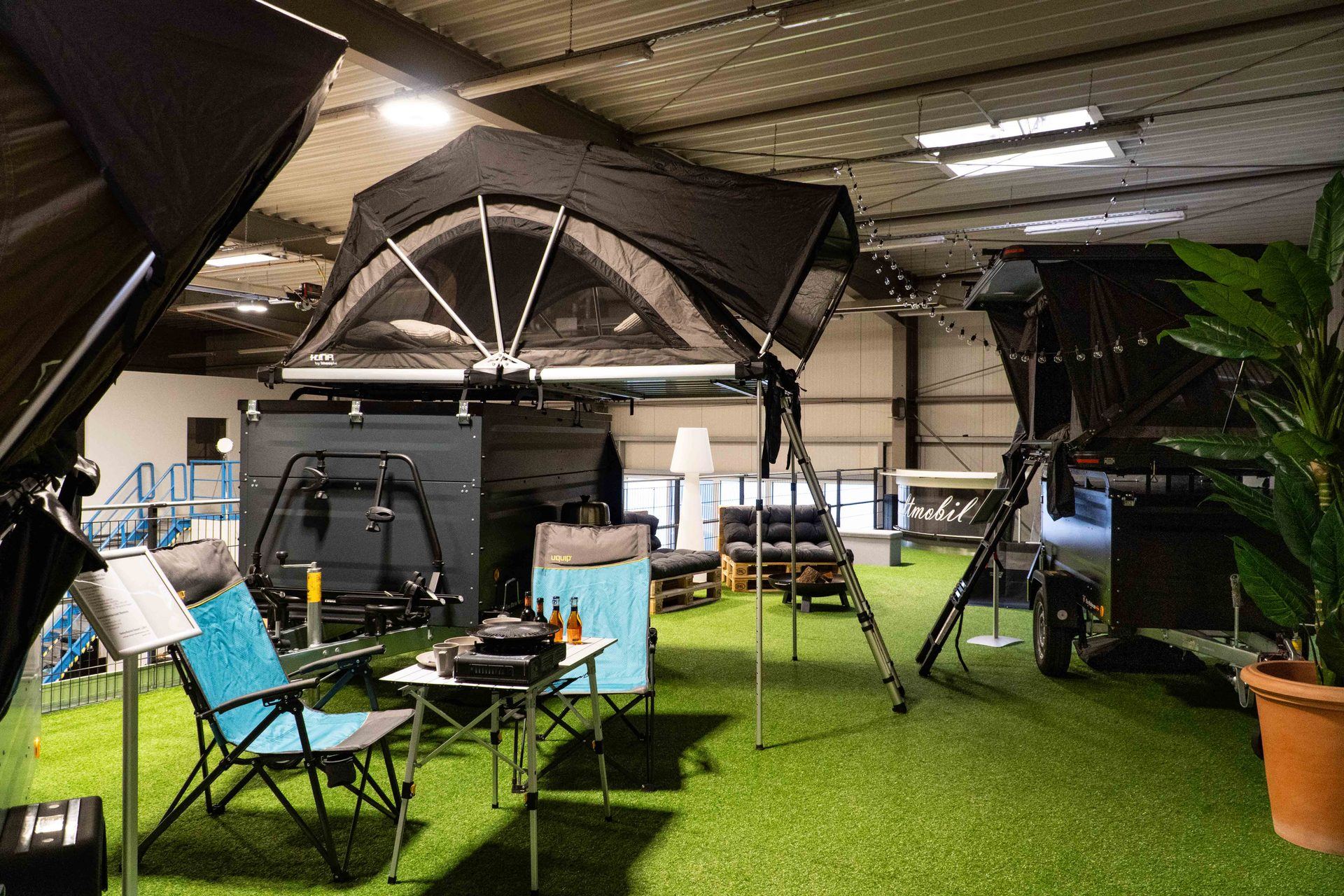Ausstellungshalle in Stuhr mit aufgebautem Dachzelt auf einem Anhänger, Campingstühlen und weiteren Dachzeltanhängern