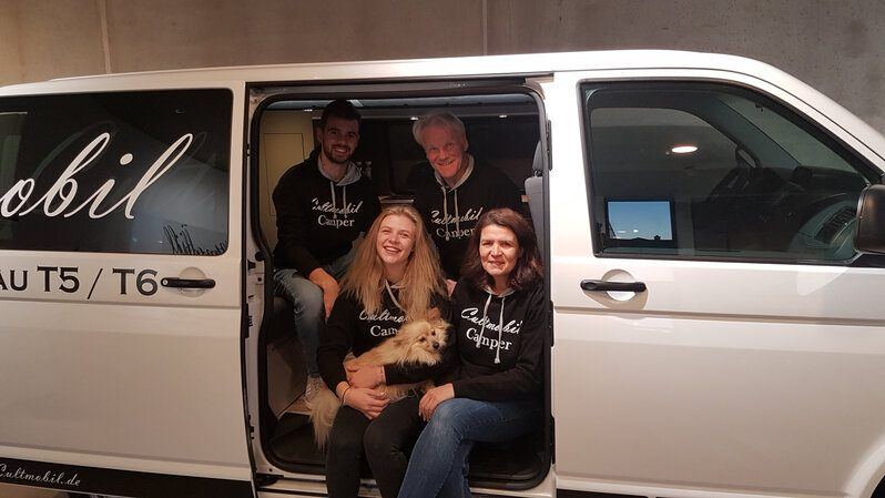 Familie Otersen und Team mit Hund in einem VW-Bus