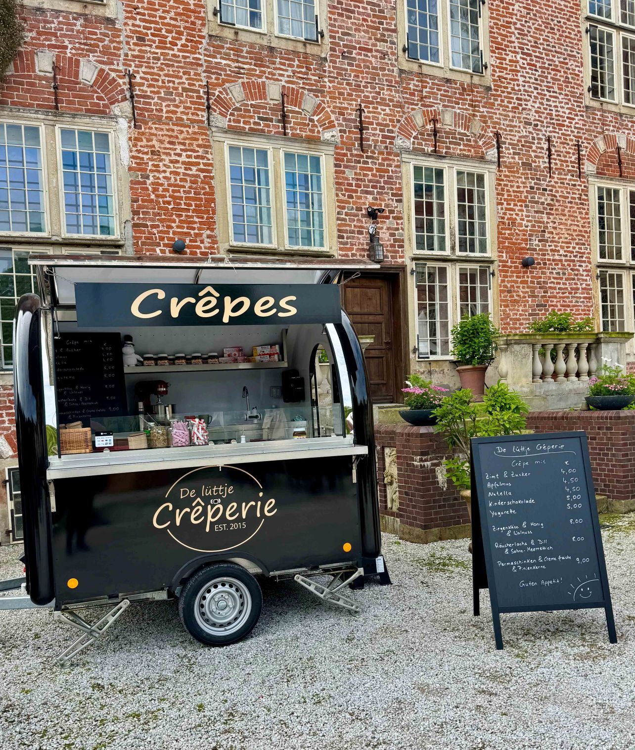 Ein Foodtrailer der Crepes vor einer schoenen historischen Kulisse anbietet